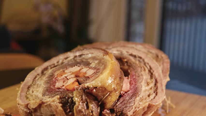 Close-up video of sliced stuffed beef ribs with calabrese sausage, bacon and vegetables. Juicy interior and golden crust shown in detail. Perfect for food content.