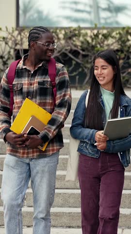 African and Asian University student friends walking and talking together on campus
