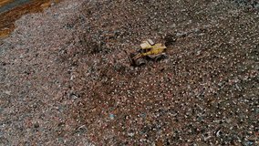 Drone view of a landfill site showing a working bulldozer among garbage piles and flying seagulls, illustrating environmental pollution and waste management. - Powered by Shutterstock - Get 15% off with code: PIKWIZARD15