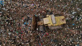 Drone view of a landfill site showing a working bulldozer among garbage piles and flying seagulls, illustrating environmental pollution and waste management. - Powered by Shutterstock - Get 15% off with code: PIKWIZARD15