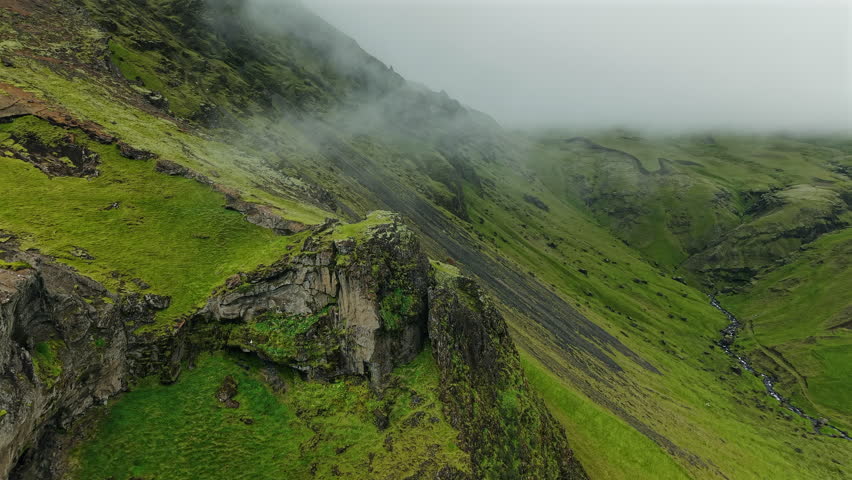 Green Mossy Cliffs with Mist in Iceland