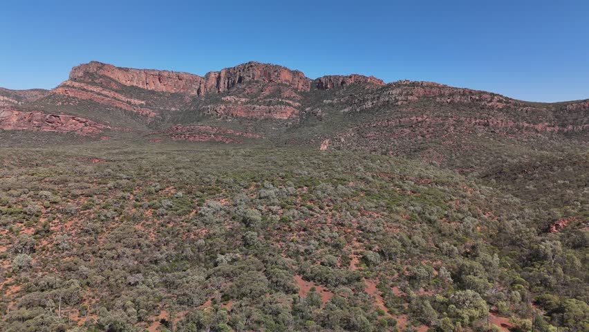 Flinders Ranges, South Australia – 4K Aerial Drone Footage of Rugged Red Cliffs, Rocky Hills, Forest, and Expansive Outback Valleys under Clear Blue Skies in Australia Inland