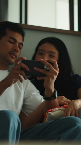 Young couple watching videos on smartphone