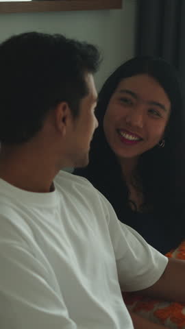 Young happy couple watching television at home