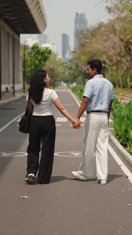 Loving couple walking hand in hand in a city park