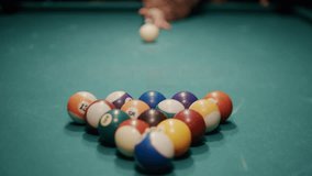 Cue ball hitting a racked triangle of balls on a green felt table, starting a game of billiards - Powered by Shutterstock - Get 15% off with code: PIKWIZARD15