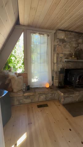Warm Scandinavian Cabin Interior with Stone Fireplace, Hammock Chair, and Minimalist Kitchen, Cozy Wooden A-Frame Home Decor with Natural Light, Neutral Tones, and Rustic Modern Mountain Retreat
