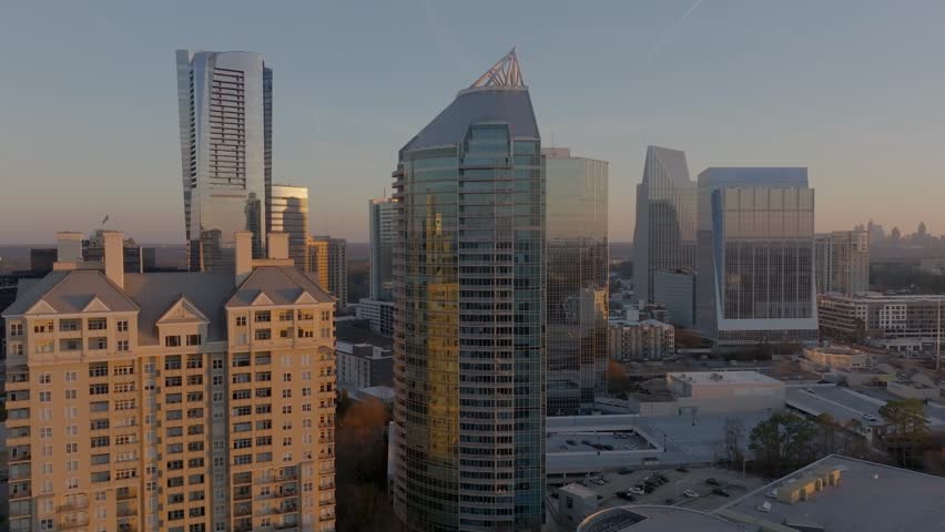 Drone shot reveals Buckhead business district, affluent neighbourhood with modern skyline buildings at sunset, Atlanta, Georgia