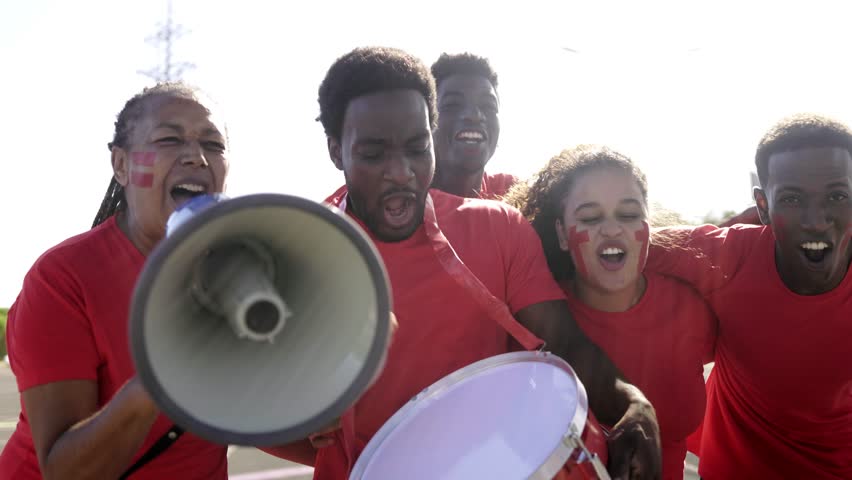 African football fans celebrate supporting red team. Sport entertainment concept - Powered by Shutterstock - Get 15% off with code: PIKWIZARD15