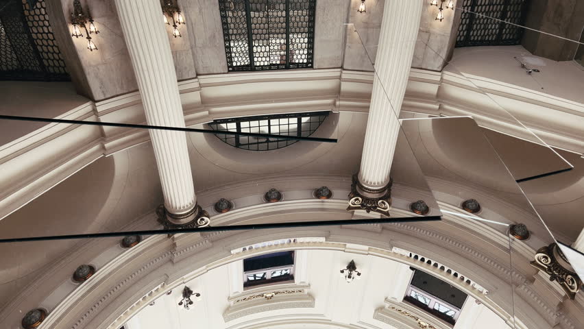 Abstract view of a mirrored art installation by José Pedro Croft in the CCBB Rio de Janeiro rotunda, reflecting and fracturing the historic Neoclassical architecture.