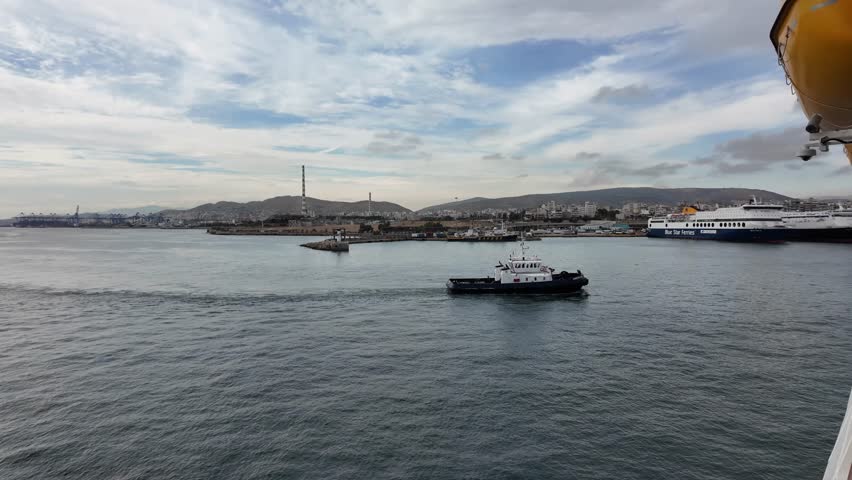 tug boat moving around Pireaus, Athens, Greece port from a cruise ship view
