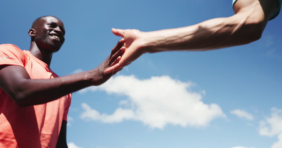 Fist bump, greeting and friends outdoor for fitness, teamwork celebration and bonding together. Low angle, happy people and secret handshake in city for workout goals, exercise support and wellness.