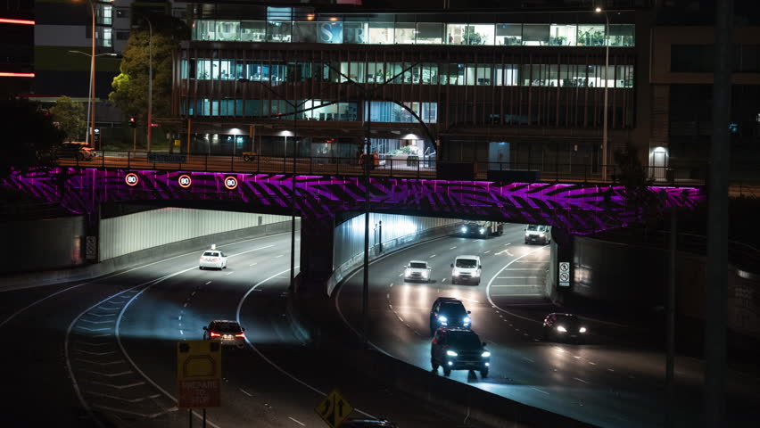 time-lapse cars driving under tunnel in city at night car lights long exposure