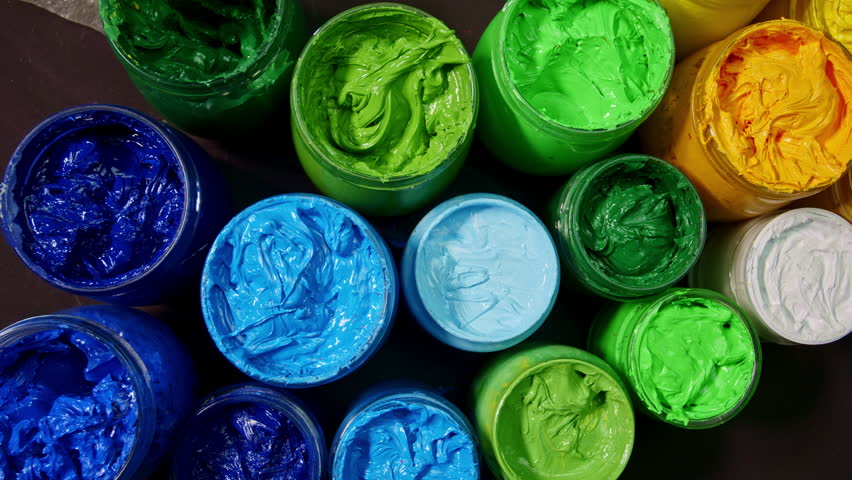 A mesmerizing top down view of open paint jars arranged in a perfect circle, each filled with thick, vibrant pigments that burst with energy and creative potential.