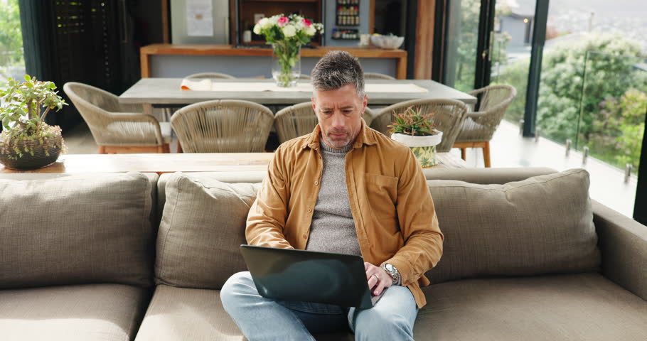 Thinking, remote work and confused man with laptop, article error and problem solving in home. Computer, freelancer and mature journalist with mistake for story, planning or reading news with glitch