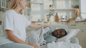 Careful wife covering her beloved sick husband by blanket in living room. Pandemic of virus, seasonal viral disease or depression, relax after dinner in weekend, dreaming in day for recovery energy - Powered by Shutterstock - Get 15% off with code: PIKWIZARD15