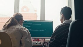 Rear view of two teenage friends discussing coding script on computer screen while programming together at home - Powered by Shutterstock - Get 15% off with code: PIKWIZARD15
