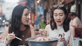 Two friends enjoying an outdoor street food meal together, showing Asian cuisine, casual dining, social gathering, friendly atmosphere and candid lifestyle moments with chopsticks and shared dishes - Powered by Shutterstock - Get 15% off with code: PIKWIZARD15
