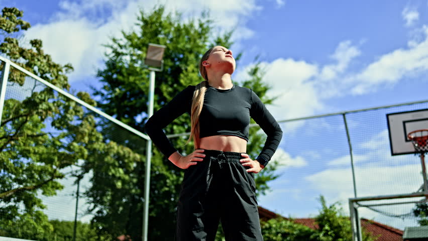 Athletic woman in sportswear doing exercises at the stadium. Warming up muscles before outdoor exercise. Woman doing sports on the sports ground in the park. Woman in sports.