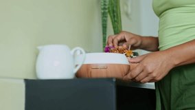 Skilled beautician carefully arranging dried flowers on wooden essential oil diffuser, complementing minimalist interior with white milk jug against dark furniture surface - Powered by Shutterstock - Get 15% off with code: PIKWIZARD15
