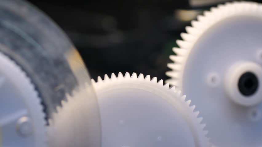 4K close-up of a 3D printer gear stepping mechanism moving precisely during printing, showing industrial precision and modern technology