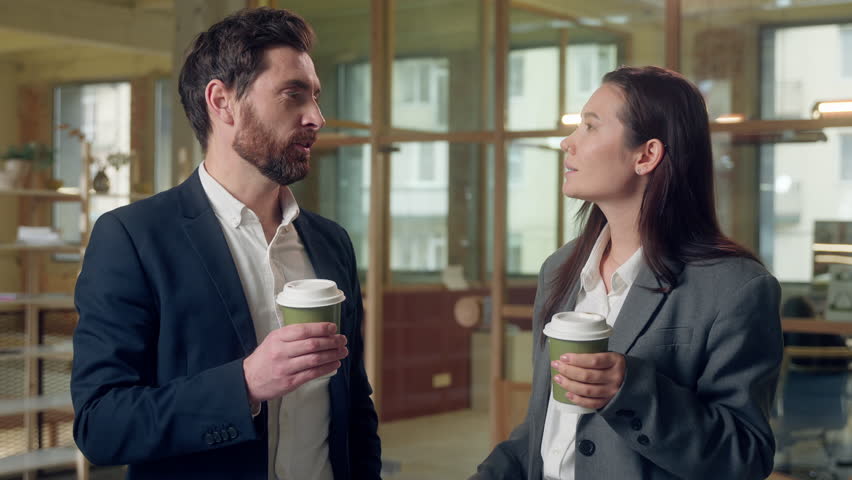 Happy multiethnic coworkers lunch break business man woman chatting drink coffee at office Korean ethnic businesswoman holding cup tea drinking beverage speaking work talk Caucasian businessman indoor