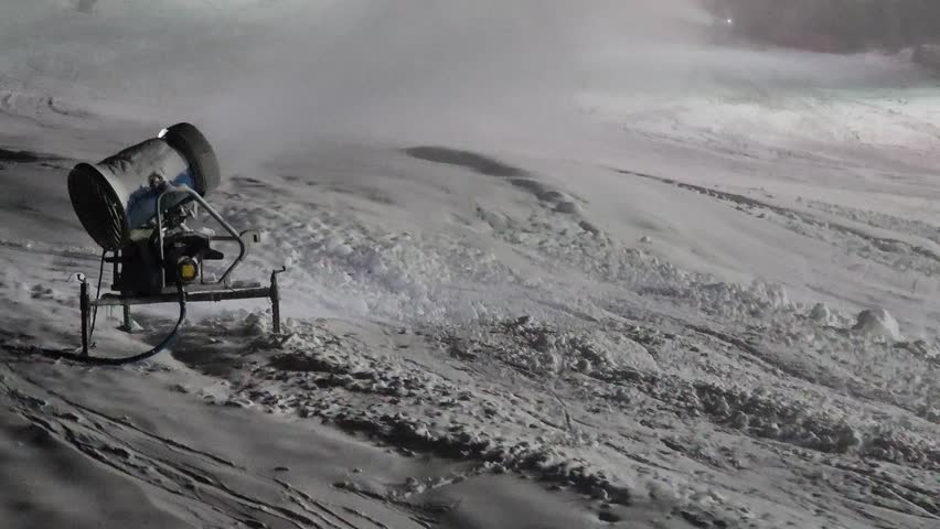 Snow cannon in winter mountains on ski resort. Snow-gun spraying artificial ice crystals on ski slopes. Machine making snow for tourists