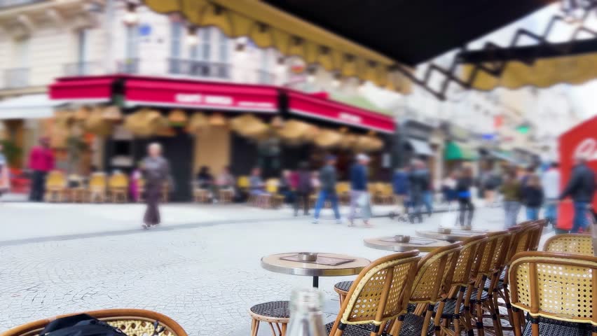 View from restourant and a busy Parisian pedestrian street with restaurants and shops in the trendy Marais district, Right Bank of the Seine River. Paris, France. Out of focus.