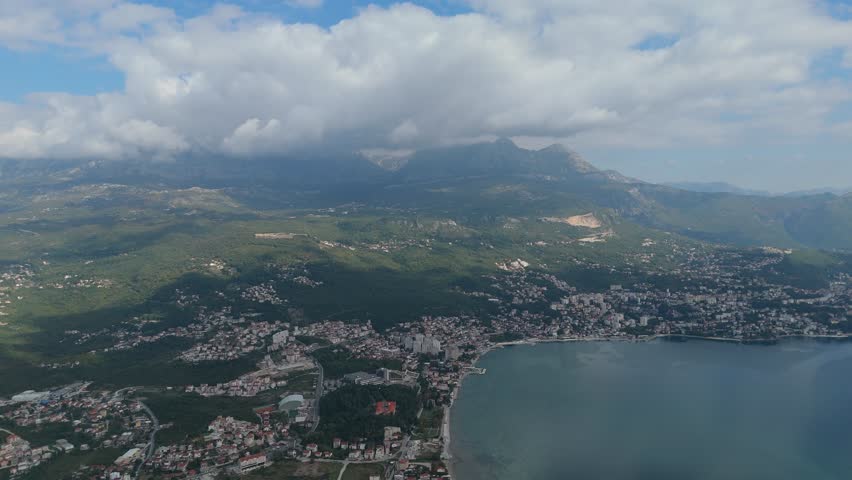 Cinematic aerial footage of Montenegro coastline near Lustica and Herceg Novi, showing turquoise water and dramatic mountain landscape.