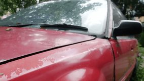 Severe rust corrosion and peeling paint damage on red car hood edge above headlight showing metal deterioration - Powered by Shutterstock - Get 15% off with code: PIKWIZARD15