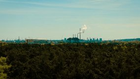 Chimney emitting white smoke above trees in Gdansk Poland. Industrial pollution spreading across urban skyline. Factory zone located near dense green forest. Air contamination contrasting with natural - Powered by Shutterstock - Get 15% off with code: PIKWIZARD15