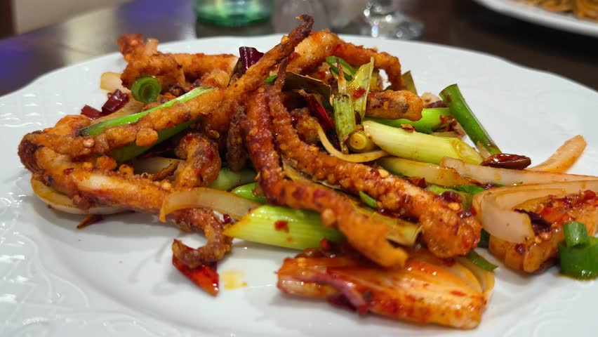 Fried squid with spicy red peppers, onions, and bay leaves. Spicy Asian dish. High quality 4k footage