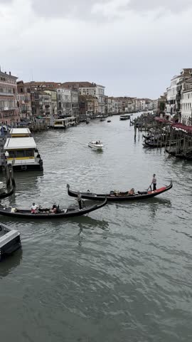 Tourists ride gondolas along the picturesque canals of Venice, surrounded by ancient buildings.