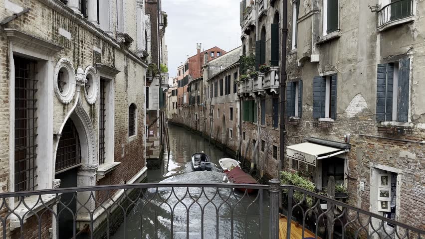 Tourists ride gondolas along the picturesque canals of Venice, surrounded by ancient buildings.