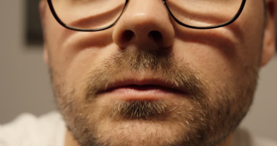 Close-up of a man making an insecure grimace, symbolizing doubt, hesitation, and emotional discomfort in a tense or awkward situation.