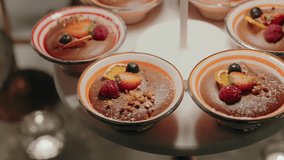 Delicious chocolate mousse desserts garnished with strawberries, raspberries, blueberries, and crushed nuts in elegant bowls - Powered by Shutterstock - Get 15% off with code: PIKWIZARD15