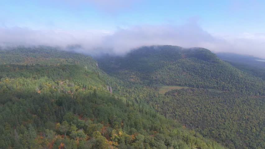 A sweeping aerial perspective captures the dense forest covering Sleeping Giant, Ontario, with layers of trees rolling toward the lake and rugged cliffs beyond.
