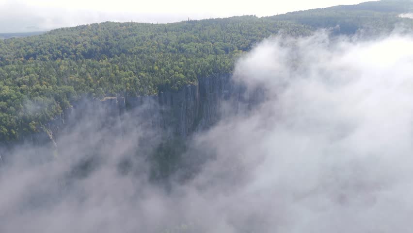 A breathtaking aerial view of Sleeping Giant, Ontario, partially veiled in soft morning fog drifting over the rugged cliffs