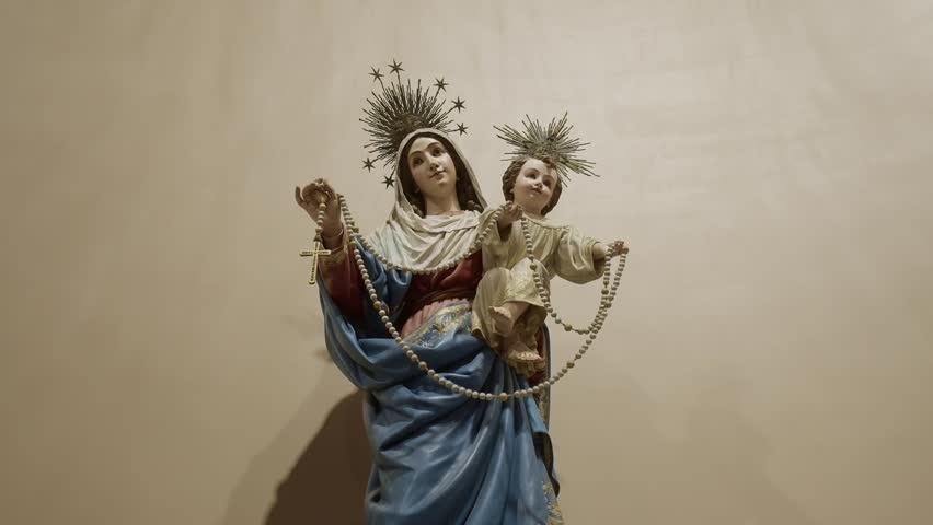 ornate statue depicting mary and child with rosary in church
