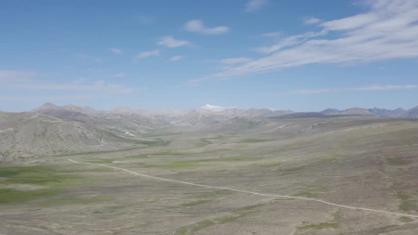 Deosai’s vast plains with winding trails and Himalayan mountains beyond. Deosai, Pakistan