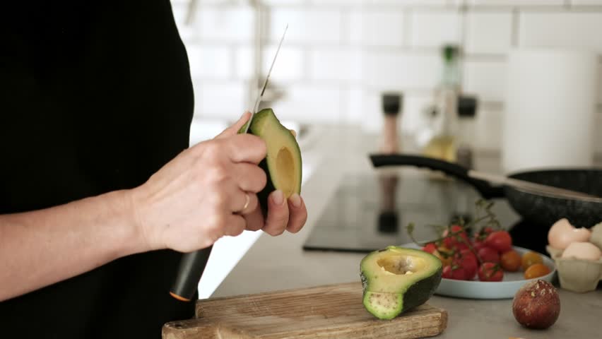 Woman Slices Avocado And Prepares Breakfast Close-Up