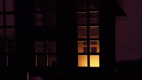 Candlelight casts flickering shadows in a dark castle, illuminating windows that reveal eerie silhouettes. The atmosphere is filled with mystery and fear as night falls. Halloween holidays - Powered by Shutterstock - Get 15% off with code: PIKWIZARD15