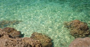 Rocky shoreline with clear shallow turquoise sea water reflecting sun in Makarska, Croatia - Powered by Shutterstock - Get 15% off with code: PIKWIZARD15