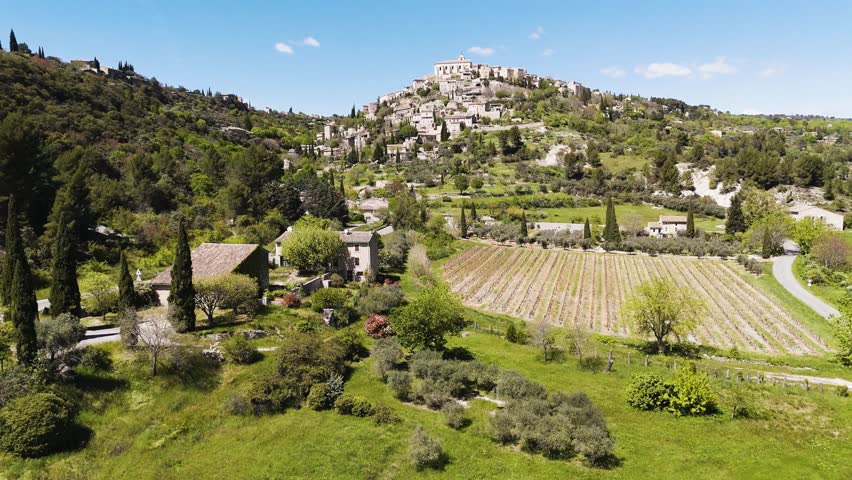 Aerial shot of Gordes, France — a hilltop village glowing under the bright southern sun.