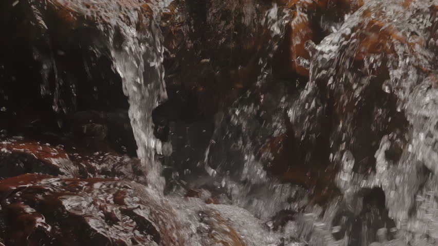 Rushing Water Over Smooth Mossy Rocks In Mountain Hike. Zoom Out Shot