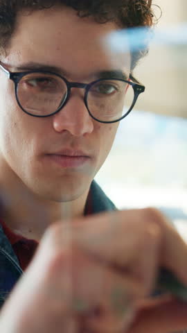 Glass, writing and man in office, planning and brainstorming for brand awareness, ideas and strategy. Marketing manager, notes and person with research for project, info and creative for campaign