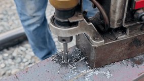 Worker operates machine tool to drill metal beams, producing shavings - Powered by Shutterstock - Get 15% off with code: PIKWIZARD15
