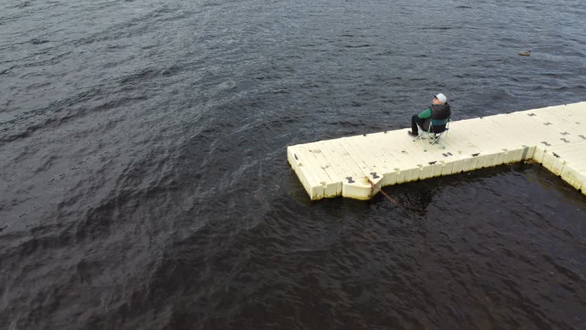 Man fishing on a floating dock at Loch Ness, Scotland