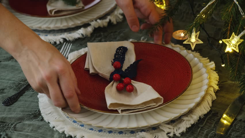 Person setting table for festive Christmas dinner. Holiday Christmas table decor.