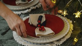 Person setting table for festive Christmas dinner. Holiday Christmas table decor. - Powered by Shutterstock - Get 15% off with code: PIKWIZARD15